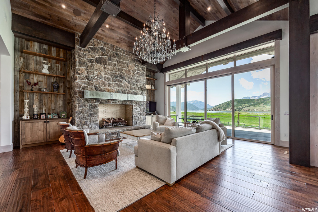 Living room with dark hardwood / wood-style flooring, a fireplace, a mountain view, and wood ceiling