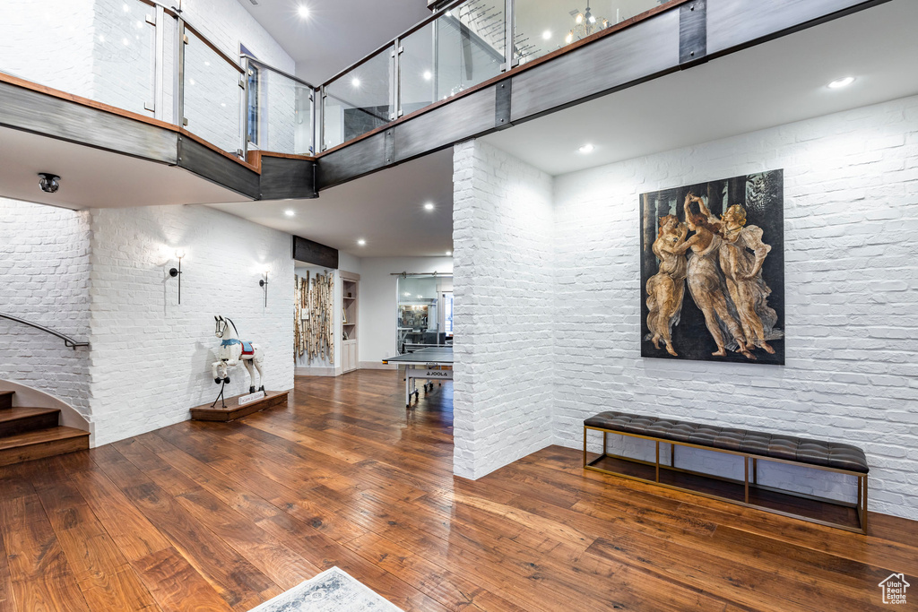 Entrance foyer featuring a towering ceiling, wood-type flooring, and stairway