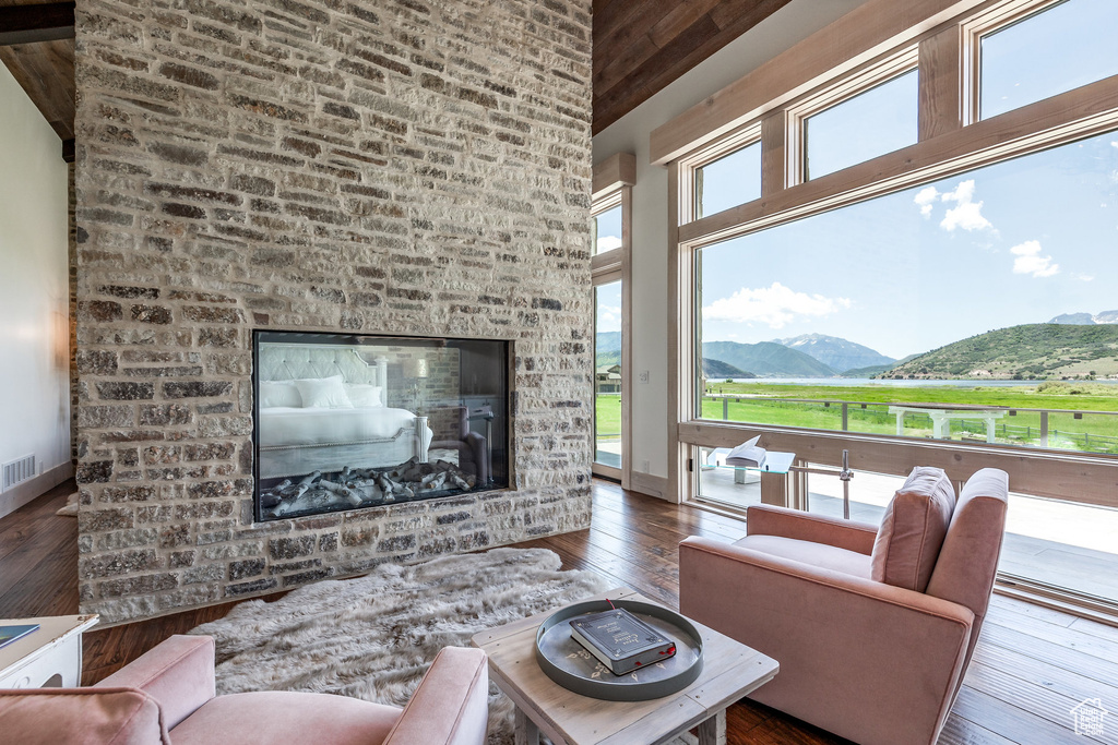 Living area with a high ceiling, wood-type flooring, a mountain view, baseboards, and wooden ceiling