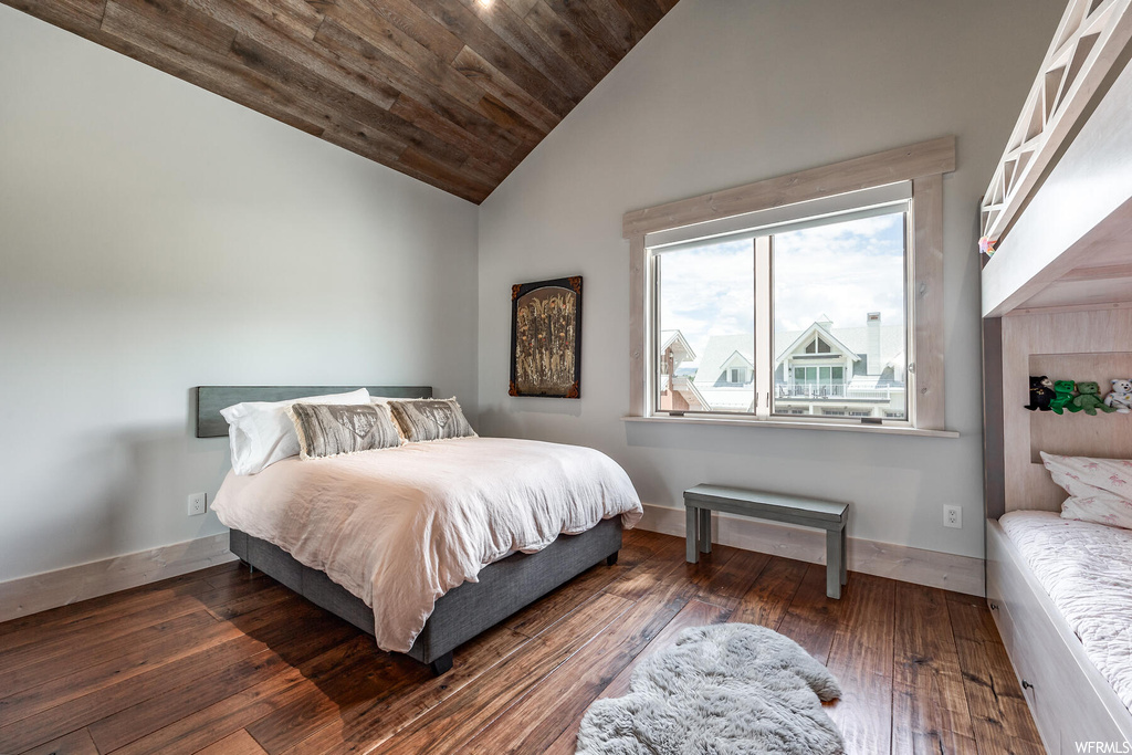 Bedroom with high vaulted ceiling, multiple windows, dark hardwood / wood-style floors, and wood ceiling