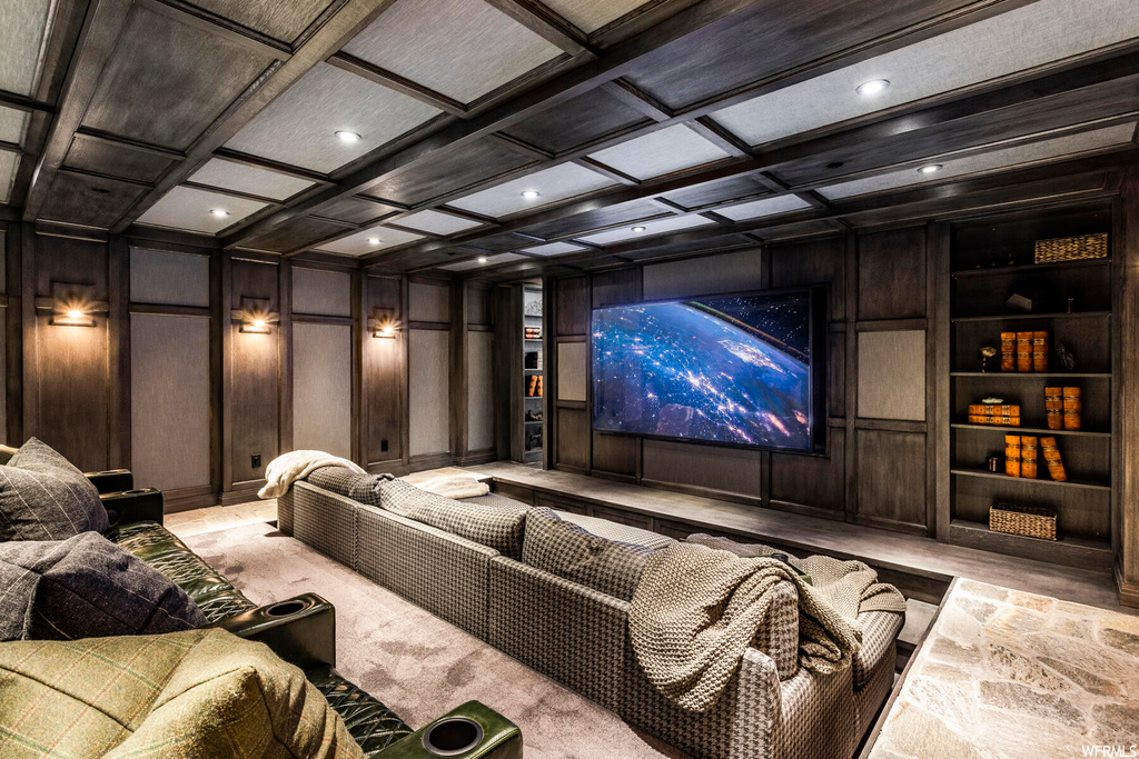 Carpeted home theater featuring wooden walls, built in features, and coffered ceiling