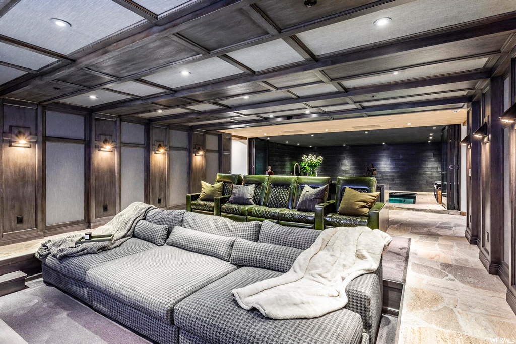 Cinema room featuring wood walls and coffered ceiling
