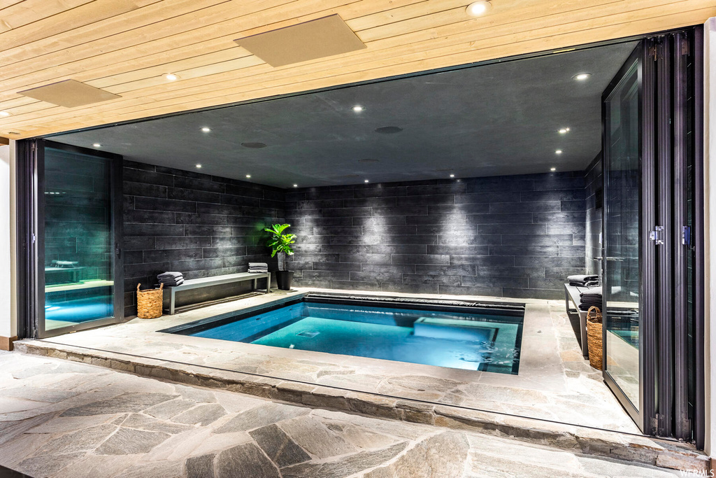 View of swimming pool featuring an indoor hot tub
