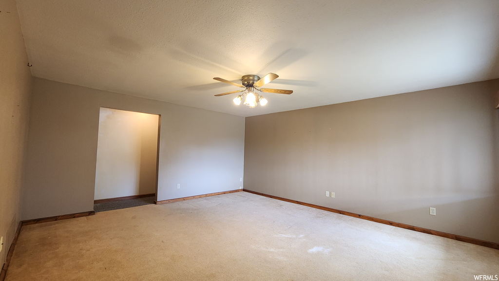 Carpeted empty room with a ceiling fan