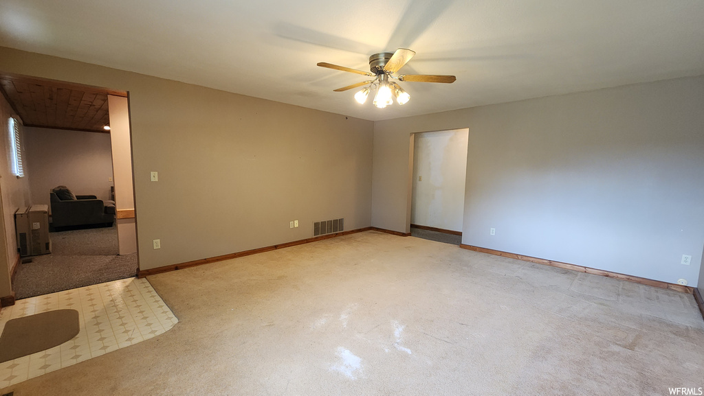 Spare room with carpet and a ceiling fan