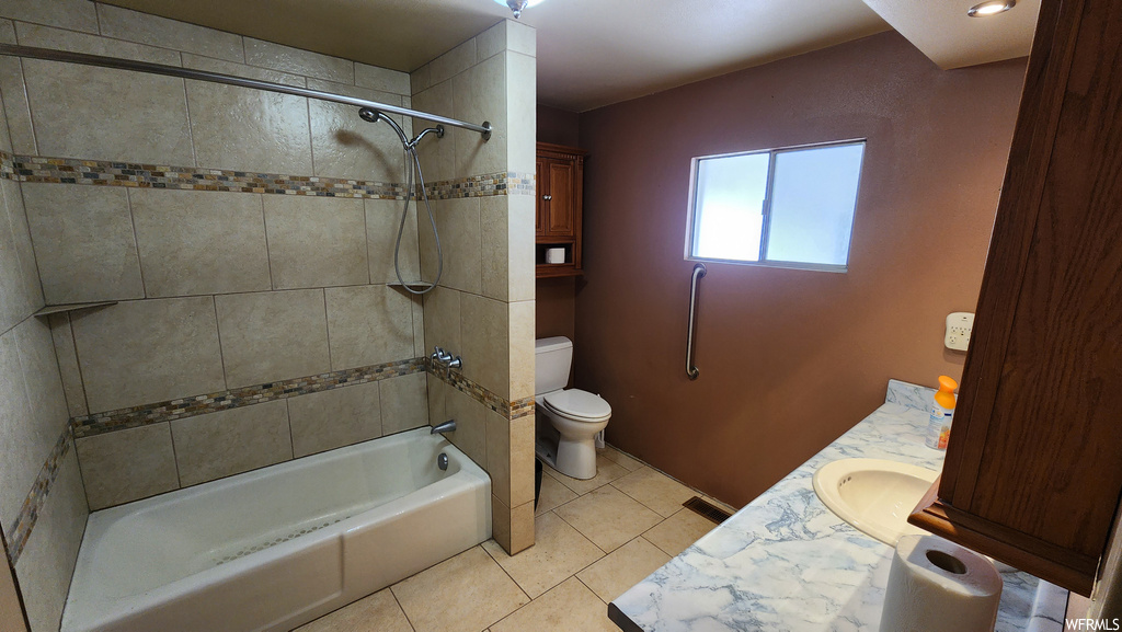 Full bathroom with natural light, tile floors, toilet, shower / tub combination, and vanity