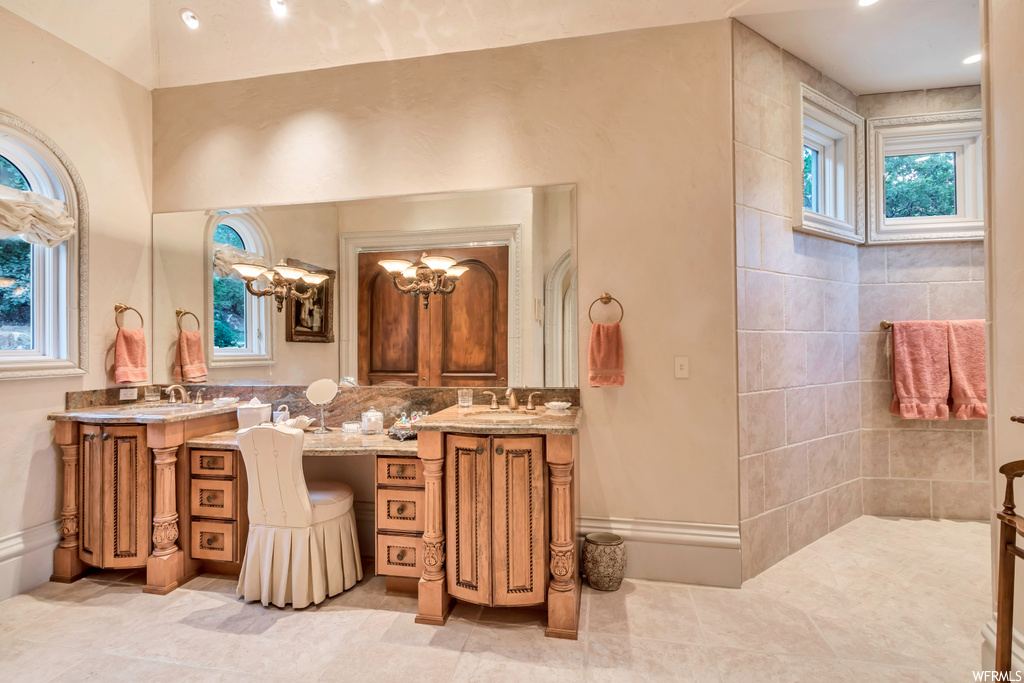 bathroom featuring tile floors, natural light, dual vanities, and multiple mirrors