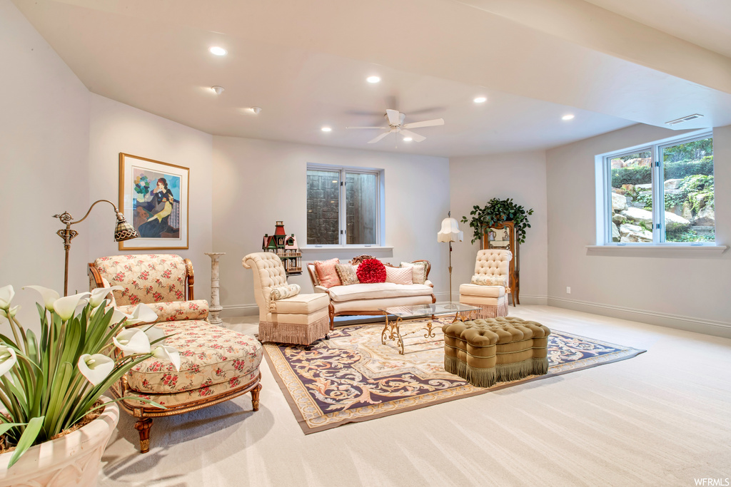 carpeted living room featuring natural light and a ceiling fan