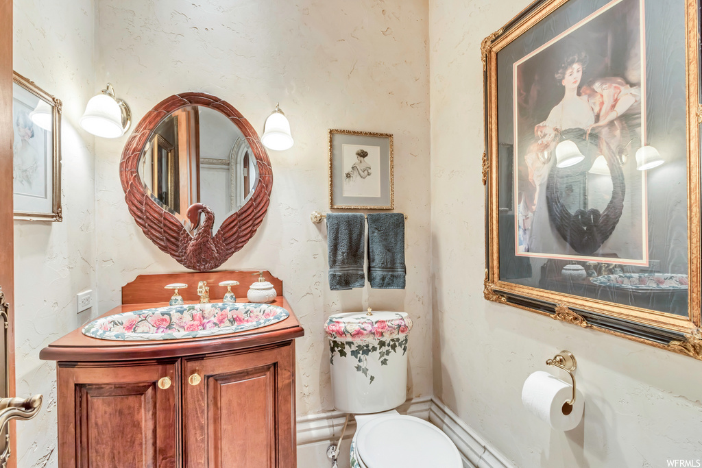 half bath featuring mirror, toilet, and oversized vanity