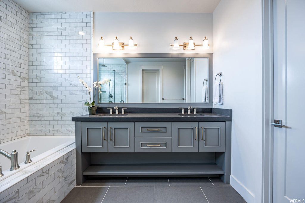 Bathroom with mirror, a tub, and double vanities