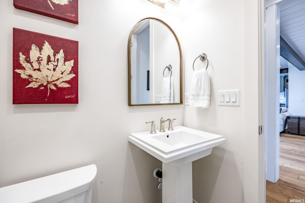 Half bathroom featuring sink, mirror, and toilet