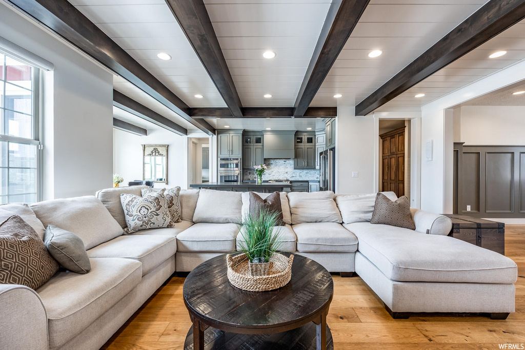 Living room with wood beam ceiling, hardwood flooring, and a wealth of natural light
