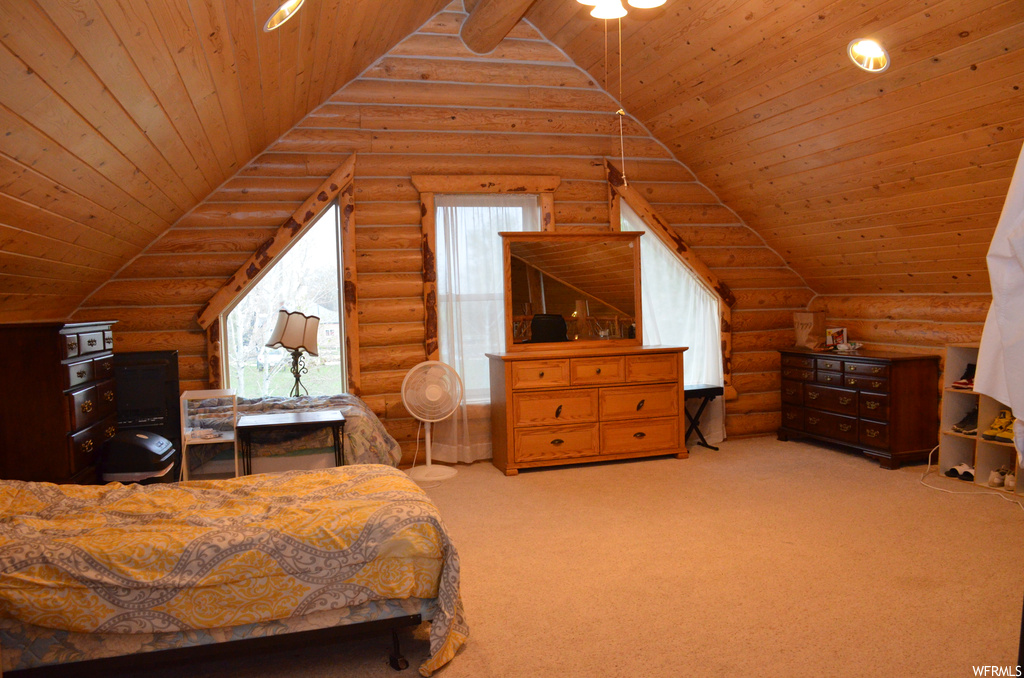 Bedroom with vaulted ceiling, carpet, and natural light
