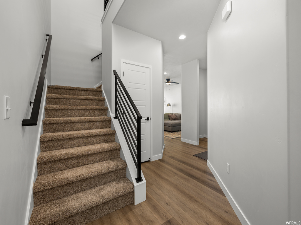 stairs featuring hardwood flooring