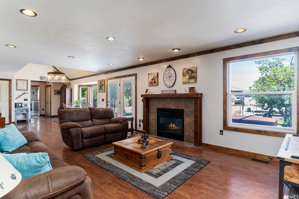 living room featuring natural light, hardwood flooring, and a fireplace