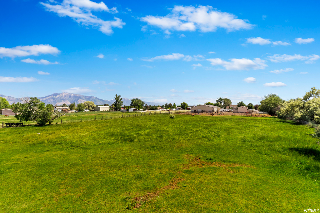 view of mother earth's splendor featuring a lawn and a mountain view
