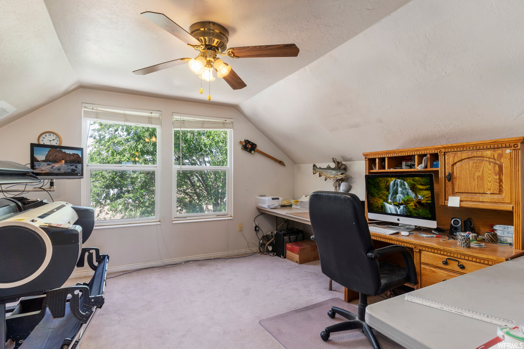 home office featuring lofted ceiling, carpet, natural light, a ceiling fan, and TV