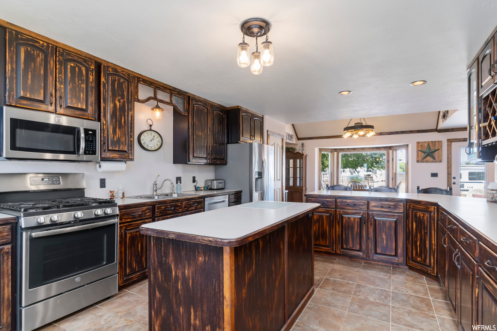 kitchen with a center island, microwave, refrigerator, gas range oven, dark brown cabinets, and light tile flooring