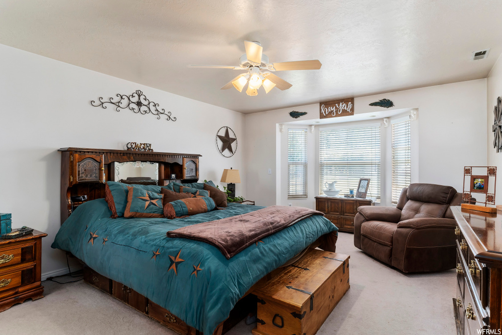carpeted bedroom featuring natural light and a ceiling fan