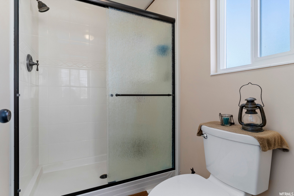 bathroom with shower with glass door and toilet