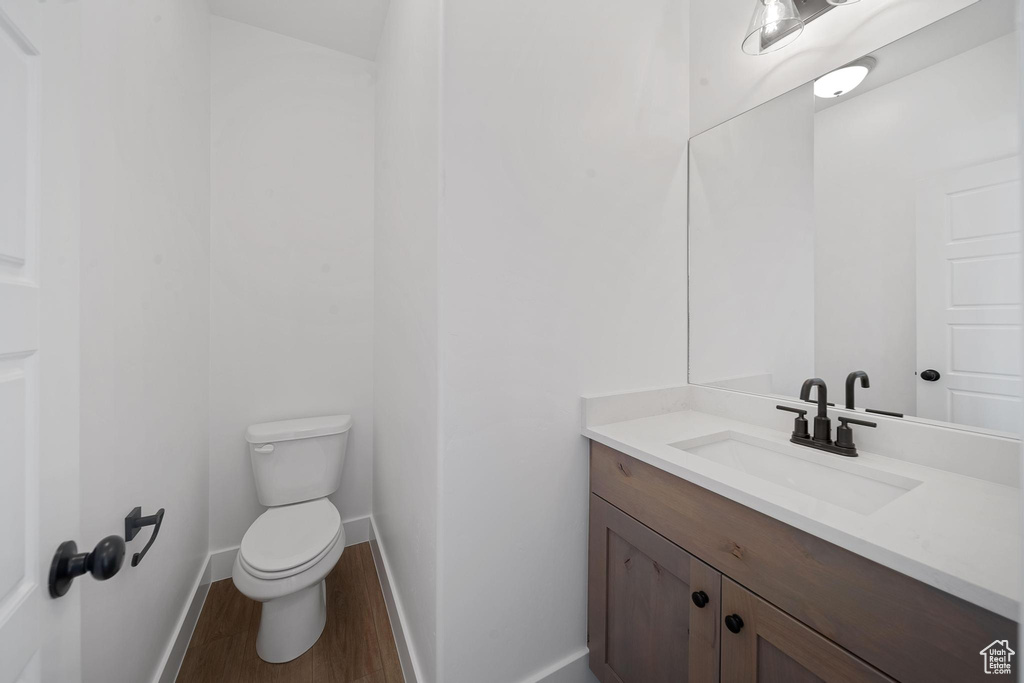 Bathroom with vanity, toilet, and hardwood / wood-style floors