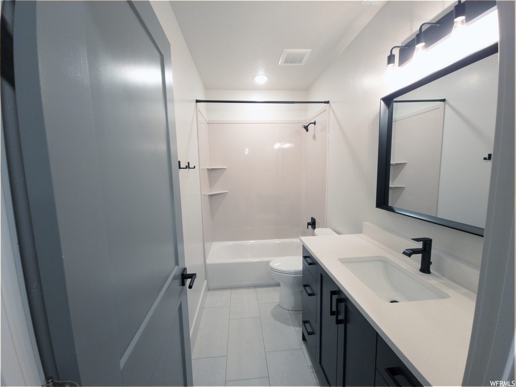 Full bathroom with bathing tub / shower combination, vanity, mirror, and light tile floors