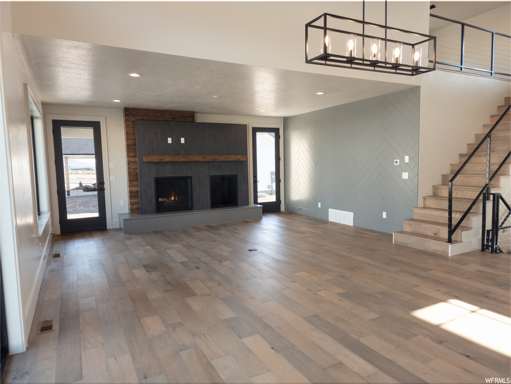 Hardwood floored living room with plenty of natural light and a fireplace