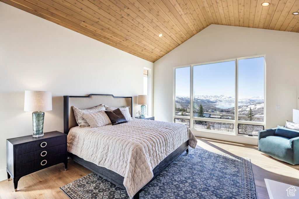 Bedroom with light hardwood / wood-style floors, high vaulted ceiling, and wooden ceiling