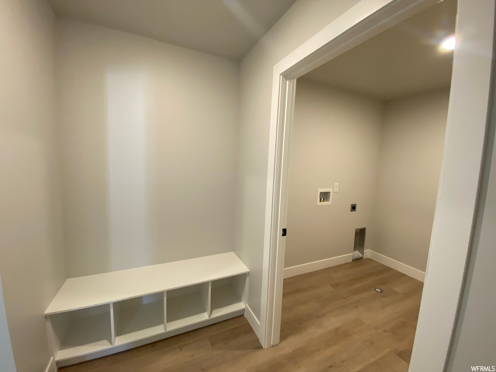 Clothes washing area featuring light hardwood floors