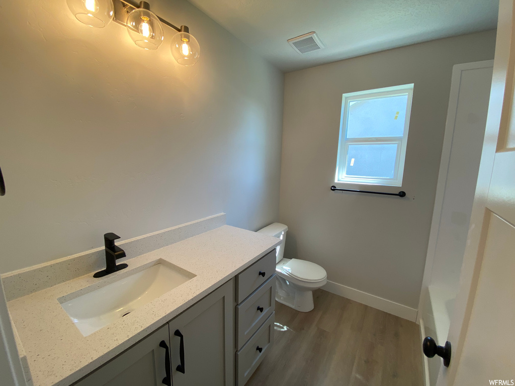 Bathroom featuring dark hardwood flooring and vanity
