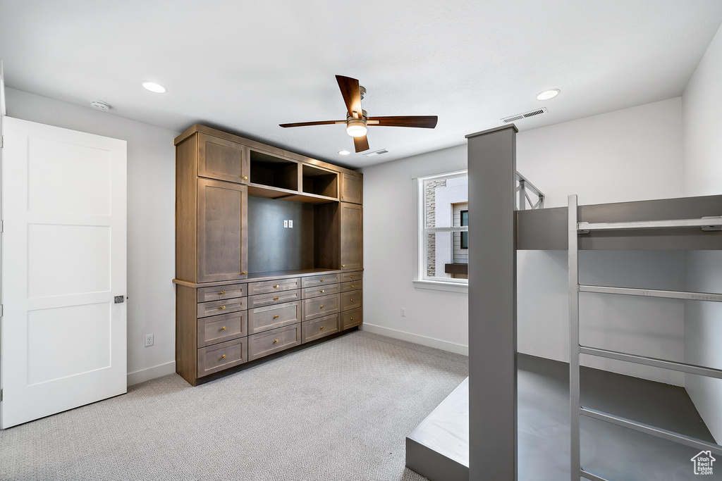 Walk in closet with ceiling fan and light colored carpet