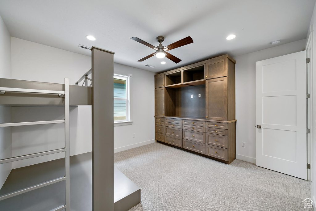 Spacious closet with light colored carpet and ceiling fan