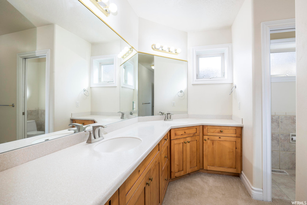 Full bathroom featuring dual sinks, independent shower and bath, a wealth of natural light, and large vanity