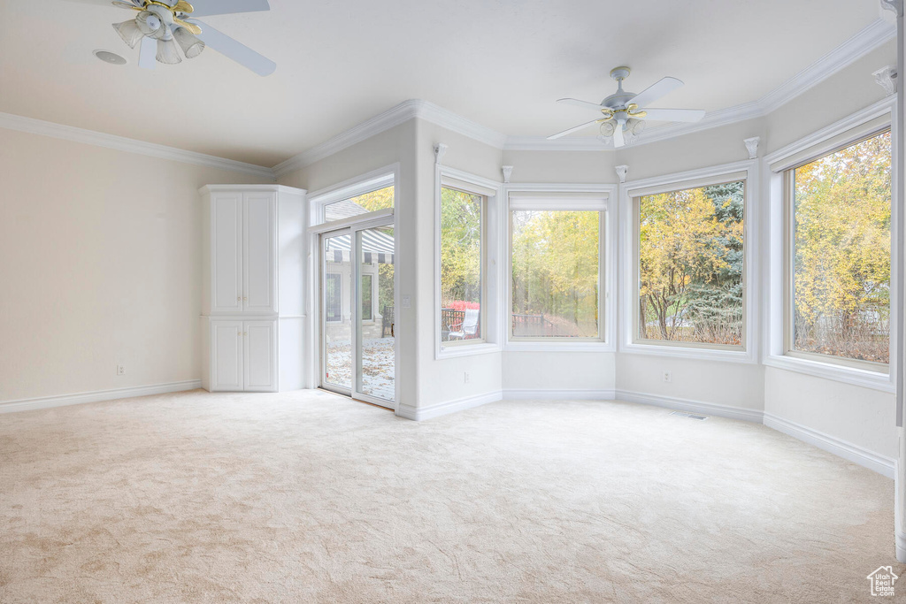 Unfurnished sunroom featuring ceiling fan