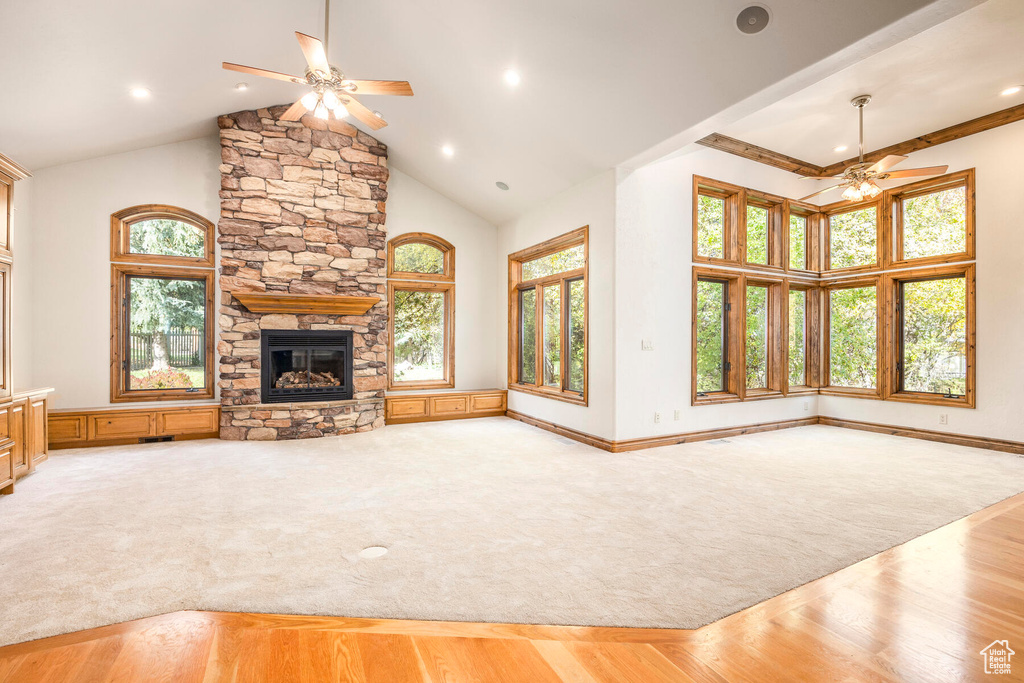 Unfurnished living room featuring plenty of natural light, ceiling fan, and light colored carpet