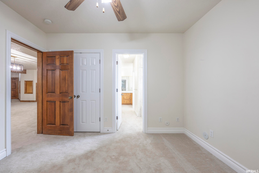 Unfurnished bedroom with light carpet, a closet, and ceiling fan