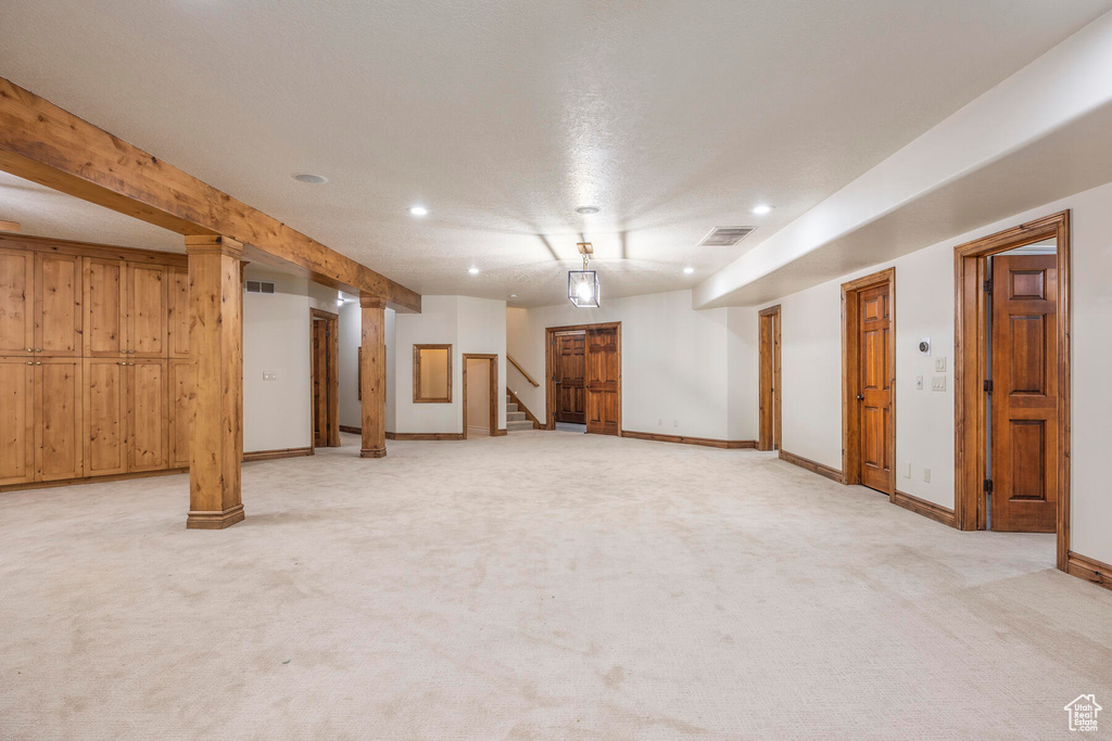 Basement featuring wood walls and light colored carpet