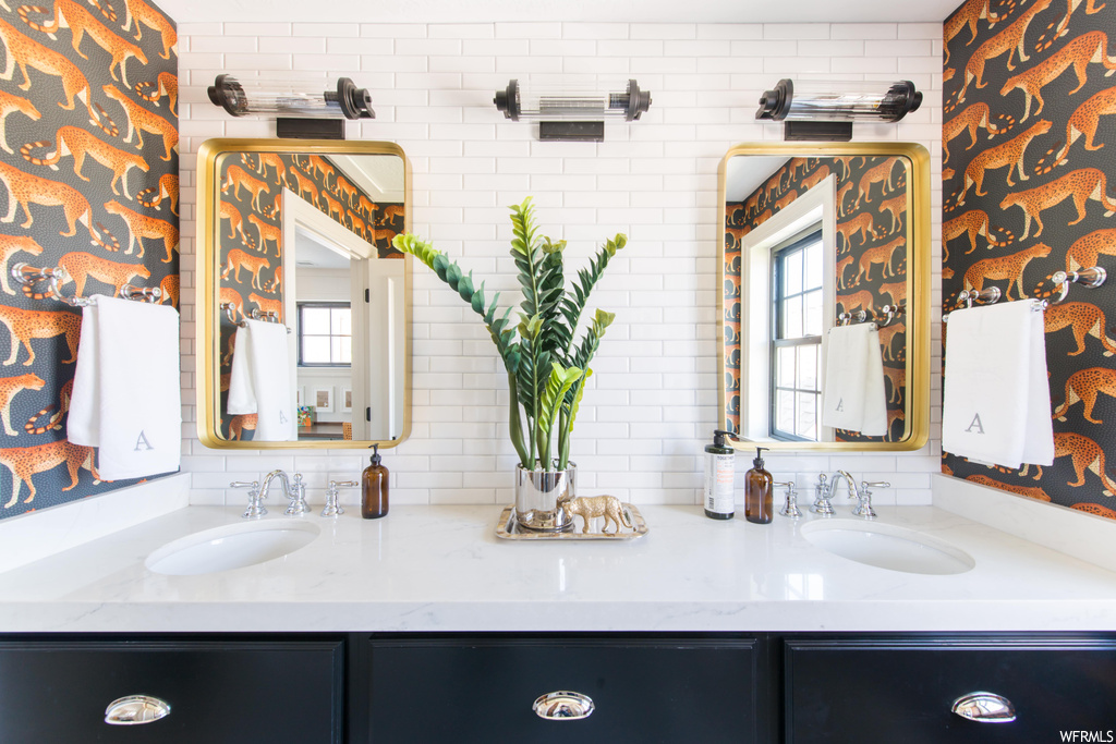 Bathroom with natural light, double large vanities, mirror, and his and her basins