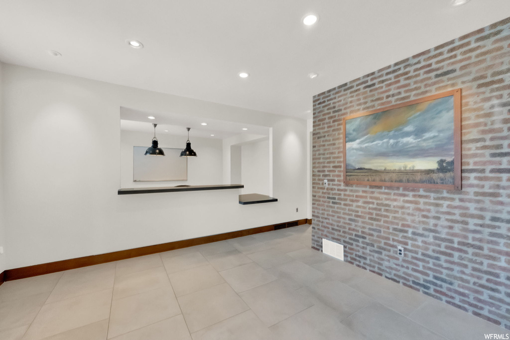 Living room with brick wall and light tile floors
