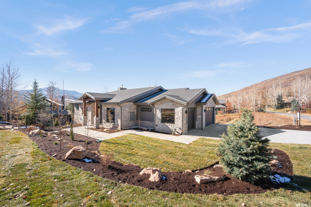 Single story home with a front yard, a garage, and a mountain view