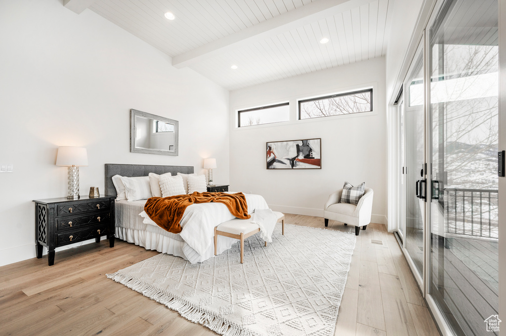 Bedroom featuring light hardwood / wood-style flooring, access to exterior, and beam ceiling