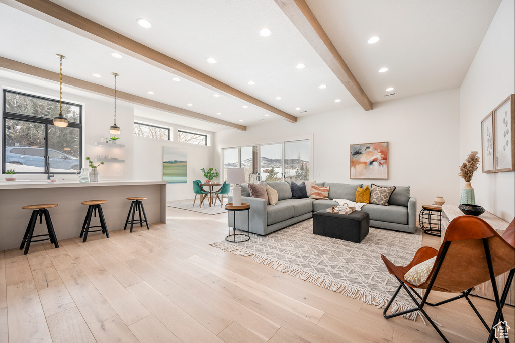 Living room with beamed ceiling and light hardwood / wood-style floors