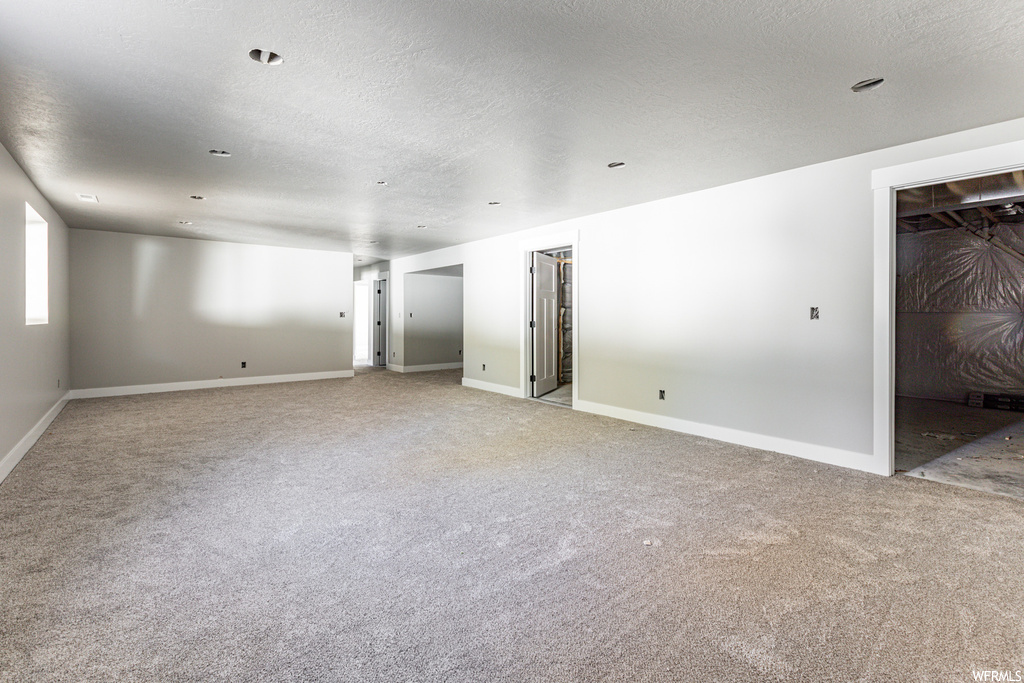 Unfurnished room with light carpet and a textured ceiling