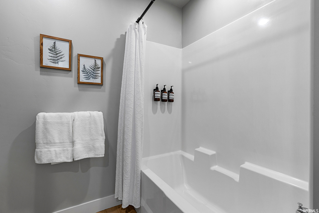 Bathroom featuring shower curtain and shower / tub combination