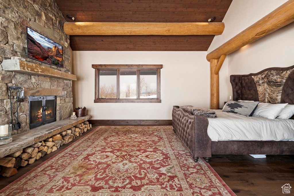 Bedroom with wooden ceiling, dark hardwood / wood-style floors, a fireplace, and lofted ceiling with beams