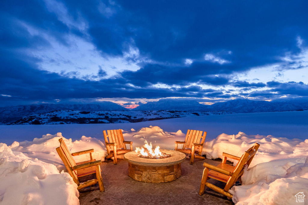 Water view with an outdoor fire pit and a mountain view