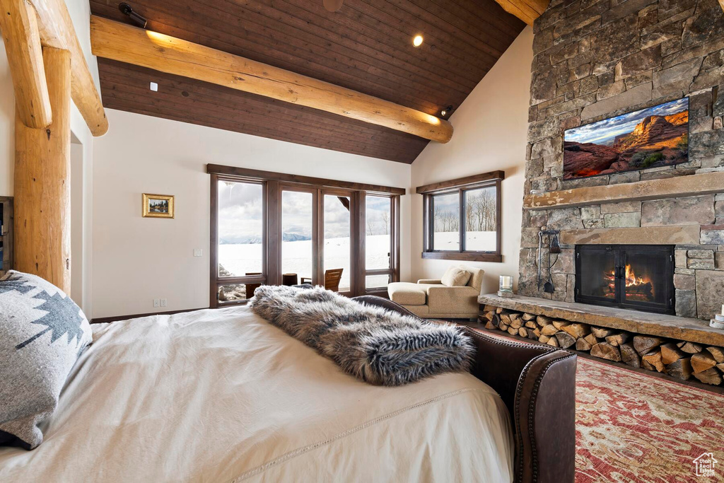 Bedroom with french doors, a fireplace, beam ceiling, access to exterior, and high vaulted ceiling