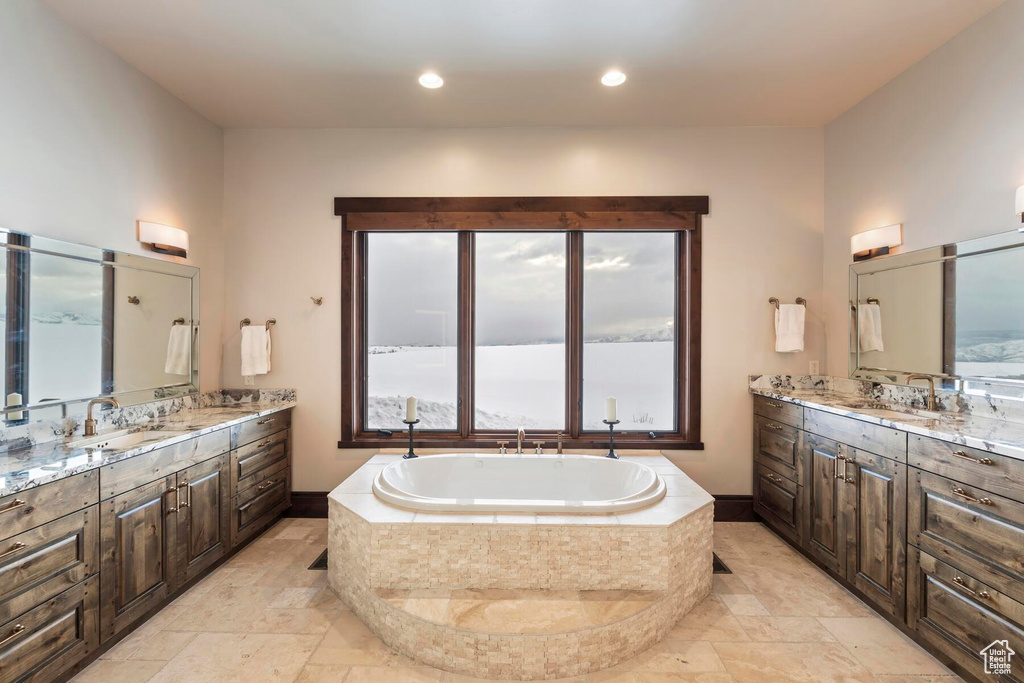 Bathroom featuring tile floors, double sink vanity, and tiled bath