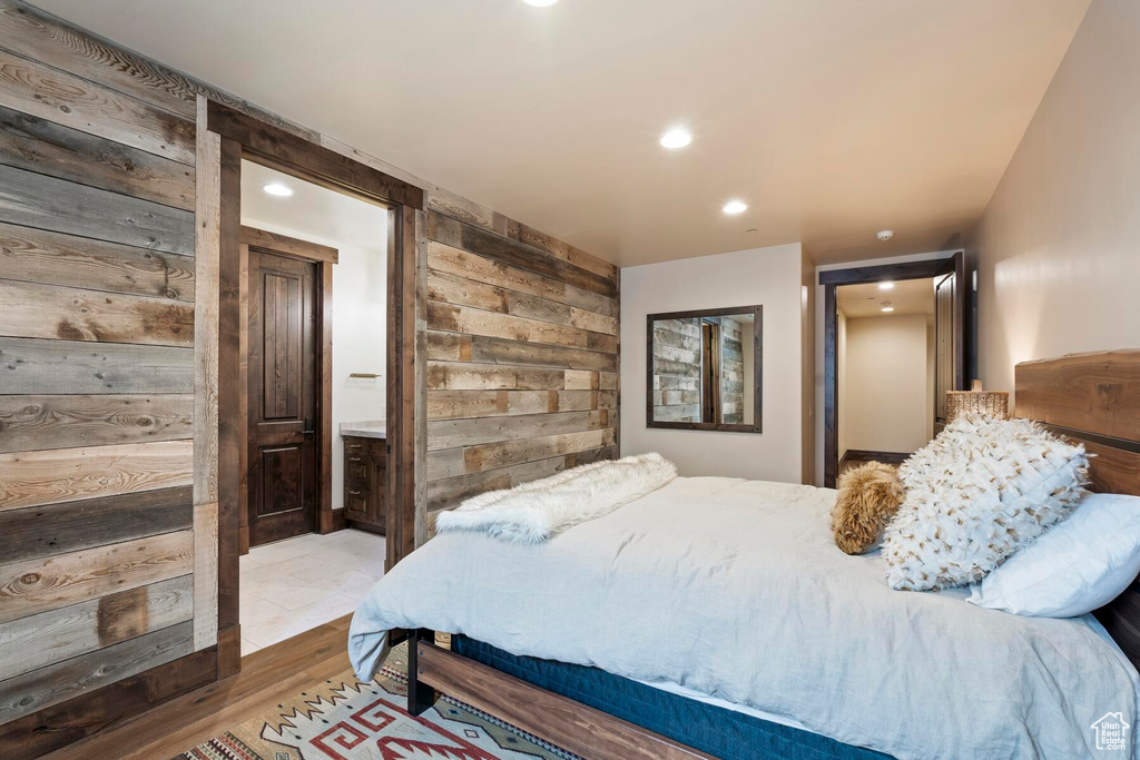 Bedroom with ensuite bathroom and hardwood / wood-style floors