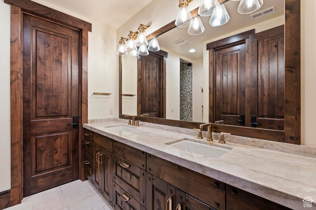 Bathroom featuring tile floors, large vanity, and dual sinks